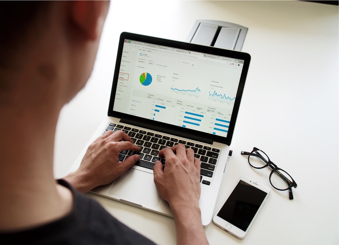 A professional analysing performance reports on two computer screens in a modern office.