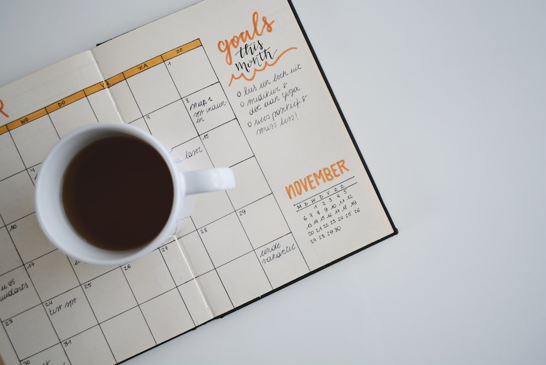 Overhead view of a desk with a handwritten editorial calendar, smartphone, coffee, and colourful sticky notes, conveying a productive and organised atmosphere.