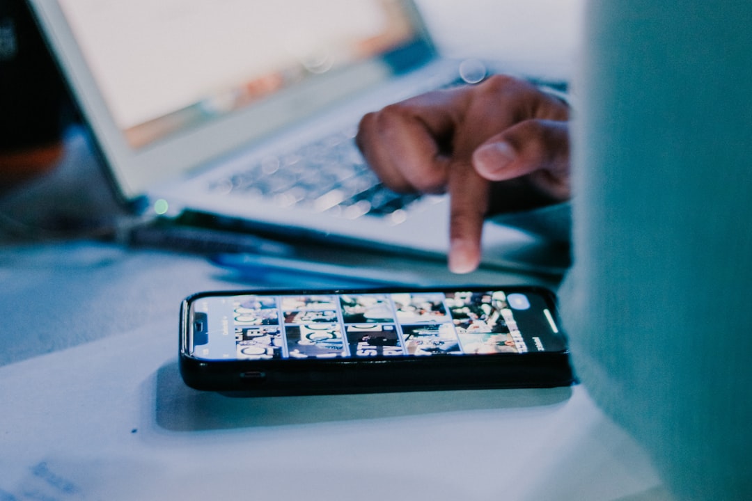 A person managing their social networks on a smartphone and tablet, with a colourful interface and dynamic atmosphere.