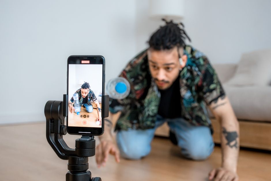Creator filming a handcrafted product with their smartphone for Instagram, warm atmosphere and golden light.